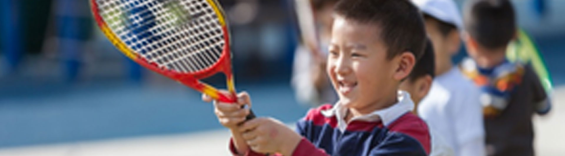 A child holding a racket, cropped